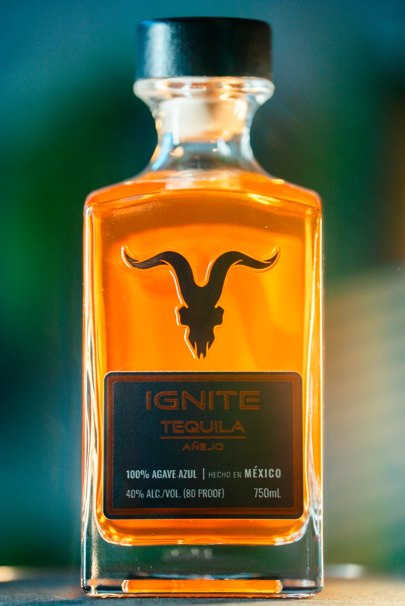 IGNITE Tequila Añejo, bottle against a blurred background