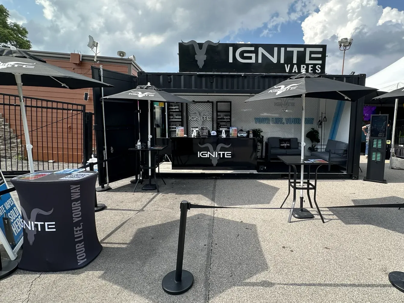 IGNITE Vapes stand with parasols, counter and lounge at a festival