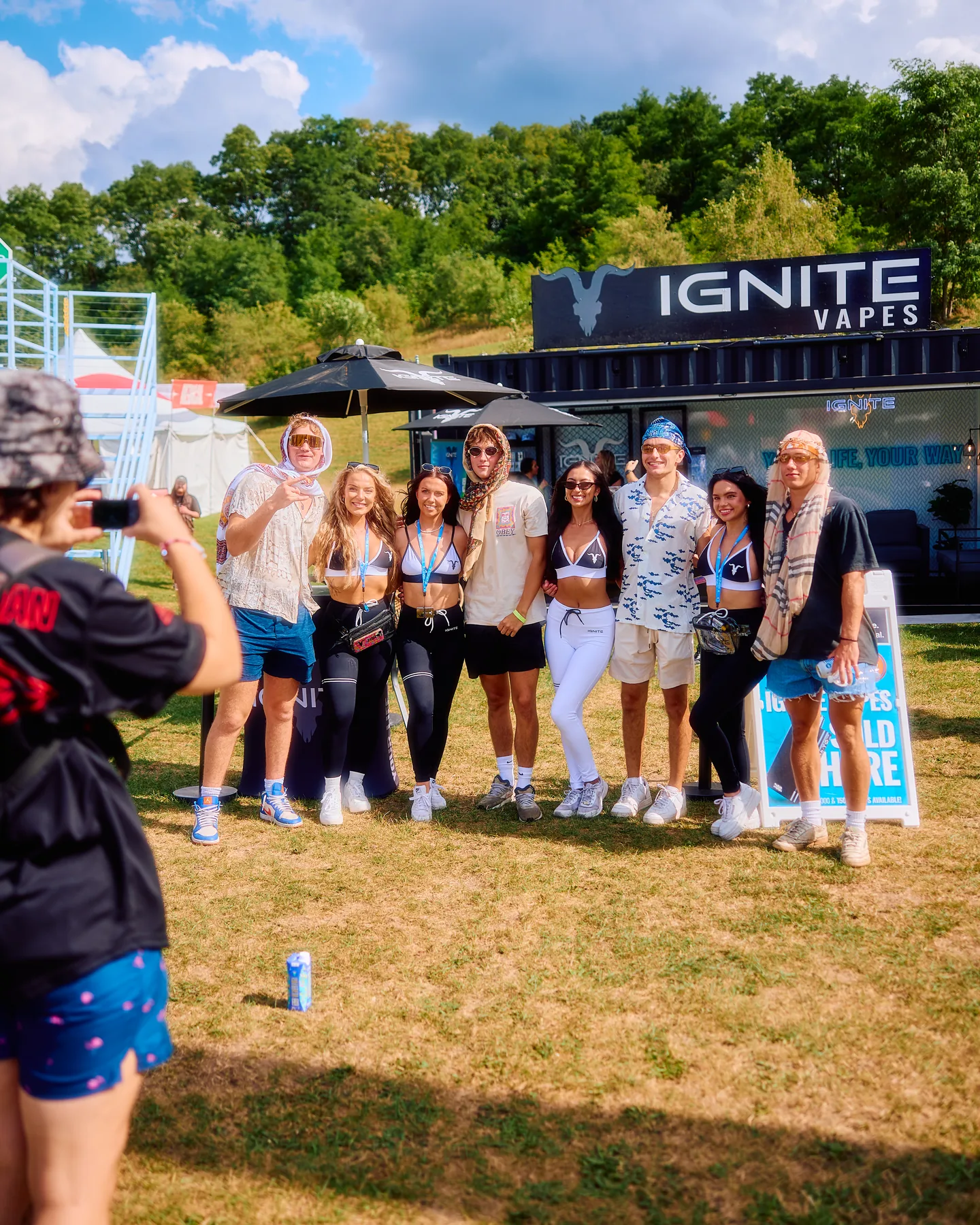Festival visitors posing with the IGNITE team in front of the IGNITE Vapes stand
